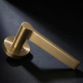 Filo Lever in Cast Brass — three-quarter view showing the flat top face of the blade