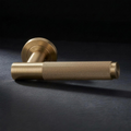 Asta Lever in Cast Brass, knurled bar lever on a round rose