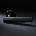 Asta Lever in Cast Black, knurled bar lever on a round rose