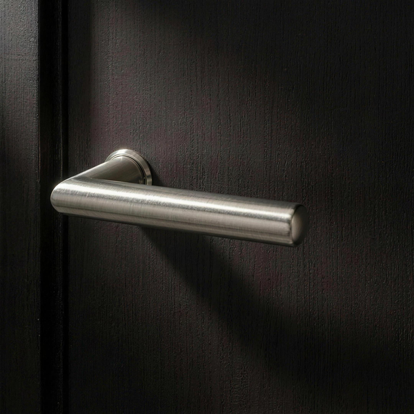 Velo Lever Round in Cast Nickel on a flush smoked-oak door