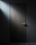Velo Lever Round in situ on a full-height smoked-oak slab door